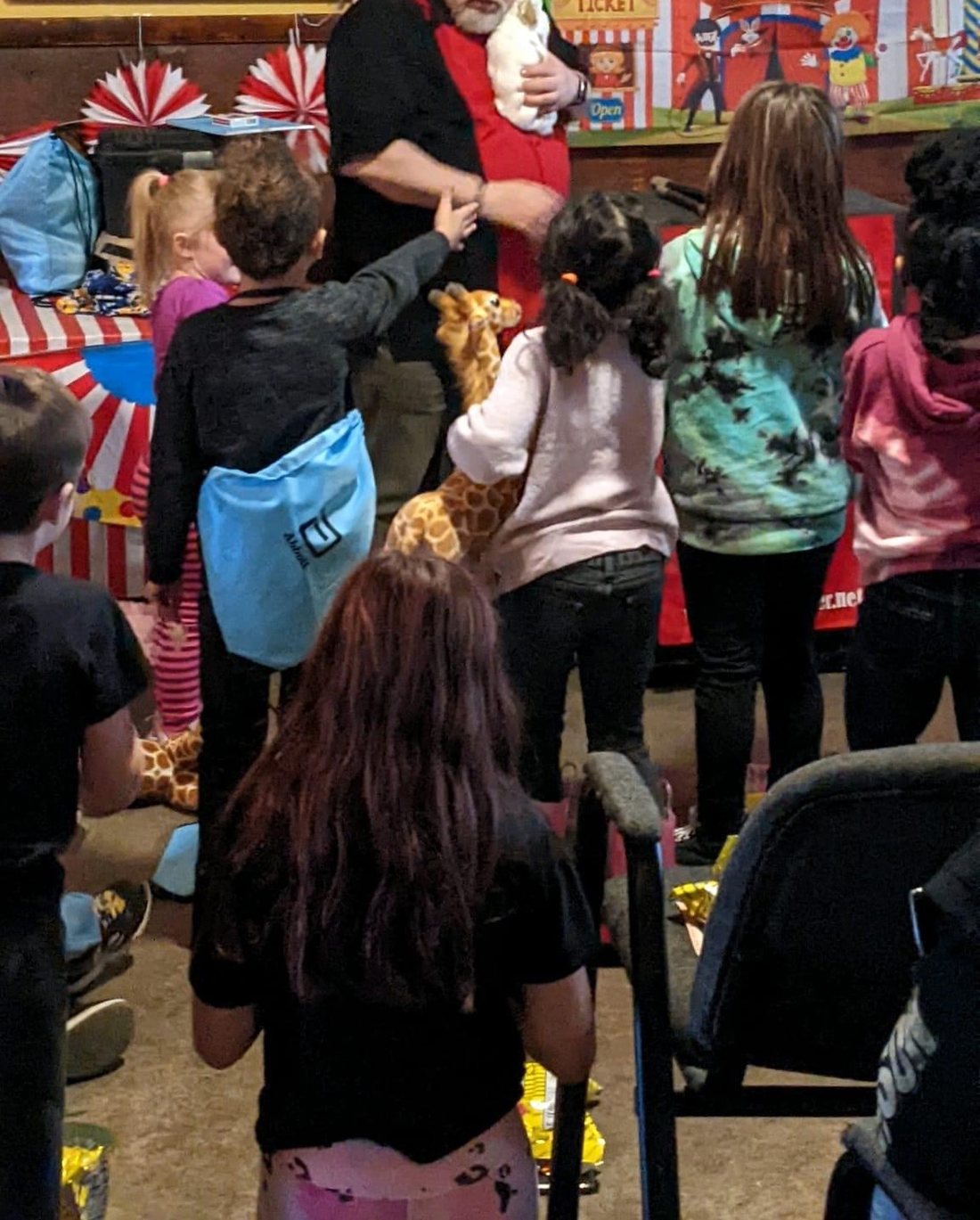 Children crowding around Carroll Baker to see the live rabbit at the end of a party show